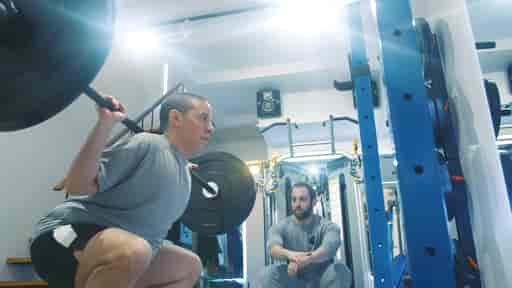 Ben performing squats in a private gym studio.