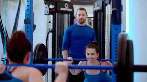 Danielle doing squats in a private gym studio.