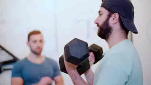 Max doing bicep curls in a private gym studio.
